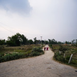 Lahan (Eastern Nepal), three women walking on a secondary road